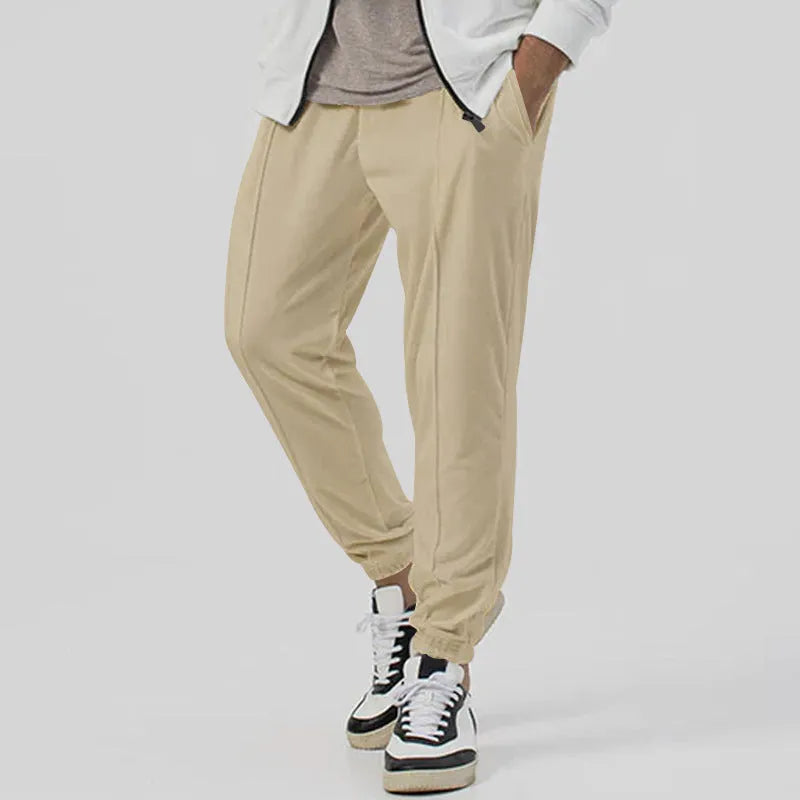 Men's grey loose tapered track sweatpants with elastic waist and straight leg design.