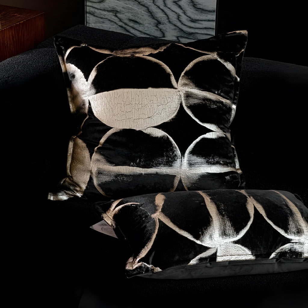 Black gold abstract pattern decorative flannel cushion on a sofa, showing removable cover.