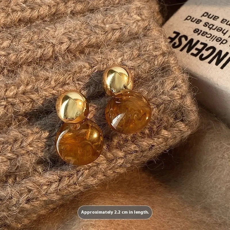 Three pairs of handmade geometric ear studs with electroplated alloy construction and tassel detailing in different colour treatments