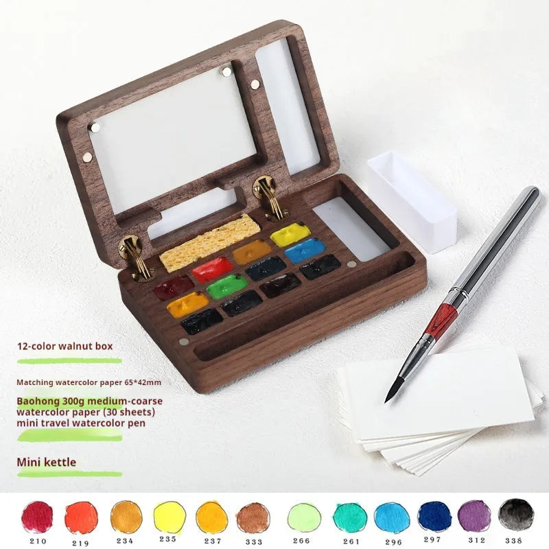 Miniature walnut wood watercolour paint box open to show pigment pans and wooden palette
