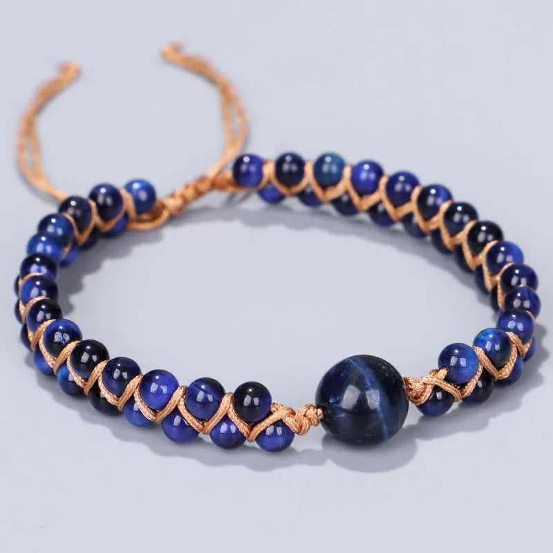Handmade woven pull bracelet in blue Tigereye or amethyst with geometric design on wrist.