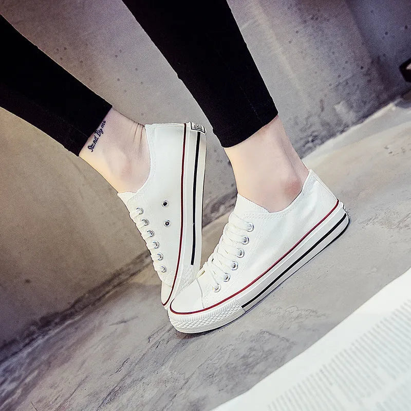 Solid colour women's canvas lace-up flats in black, shown on a white background.