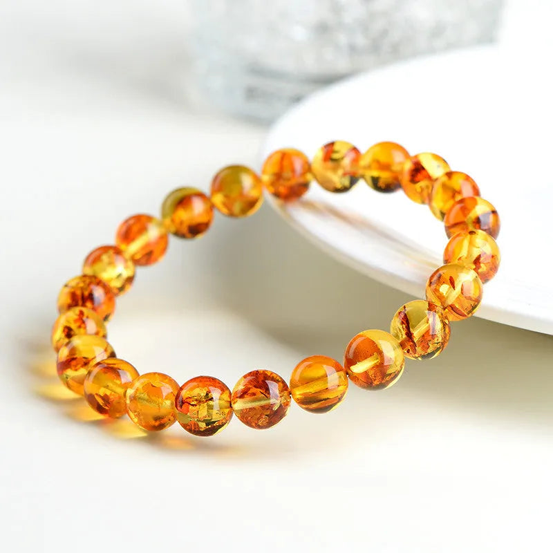 Natural yellow piebald amber bracelet with geometric beads on wrist