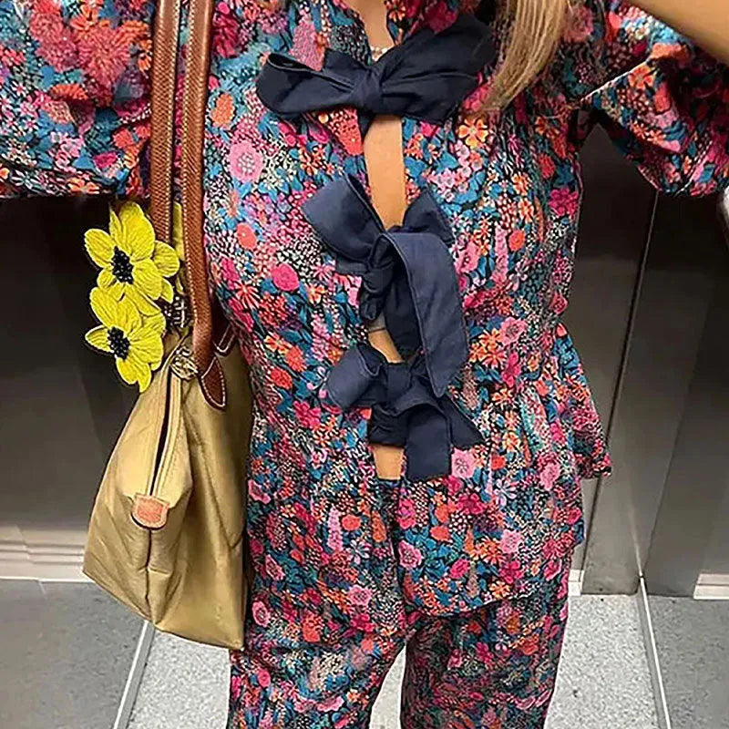 Floral print trousers suit with tie-neck blouse featuring puff sleeves and matching trousers