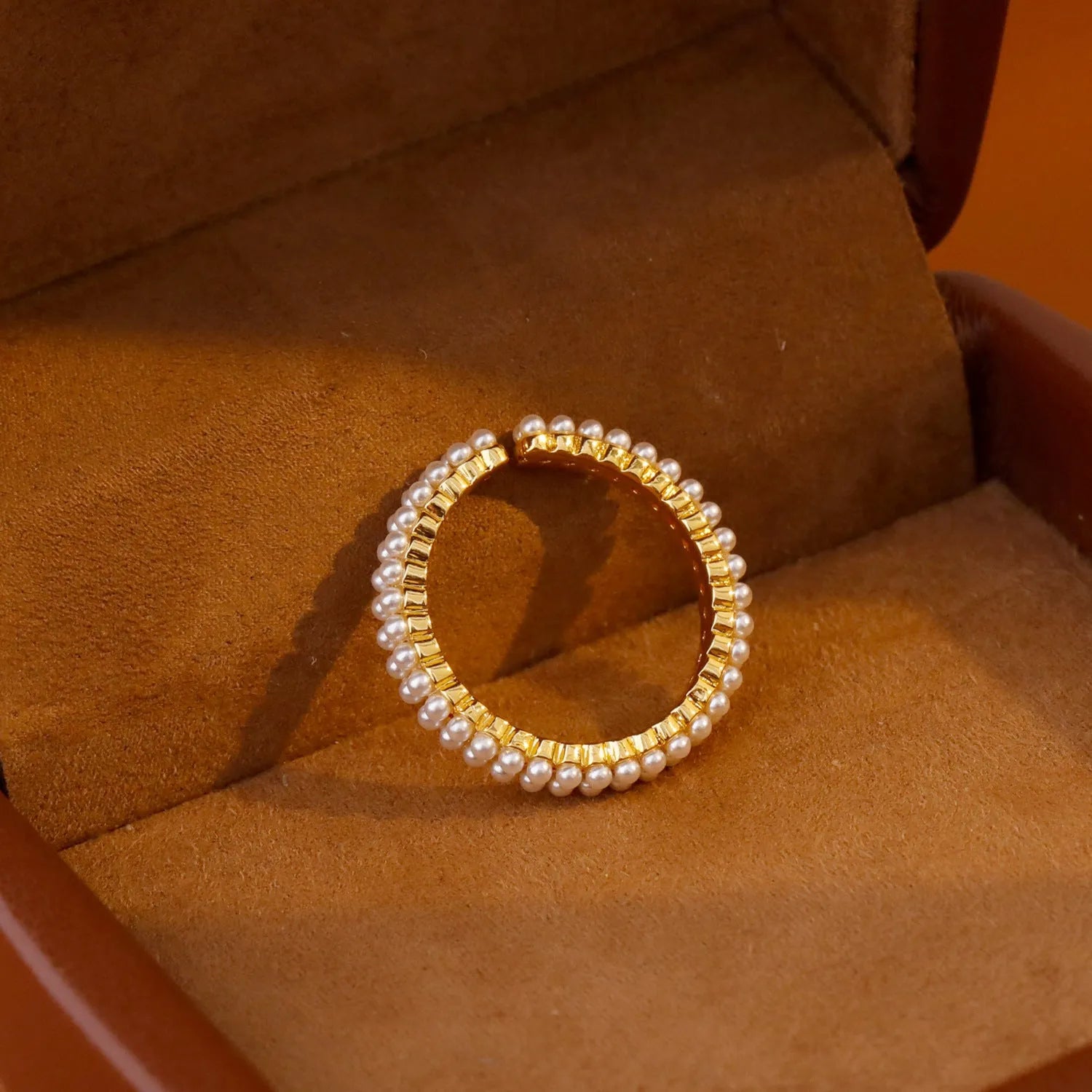 Gold geometric open mouth ring with round decorative elements on female hand