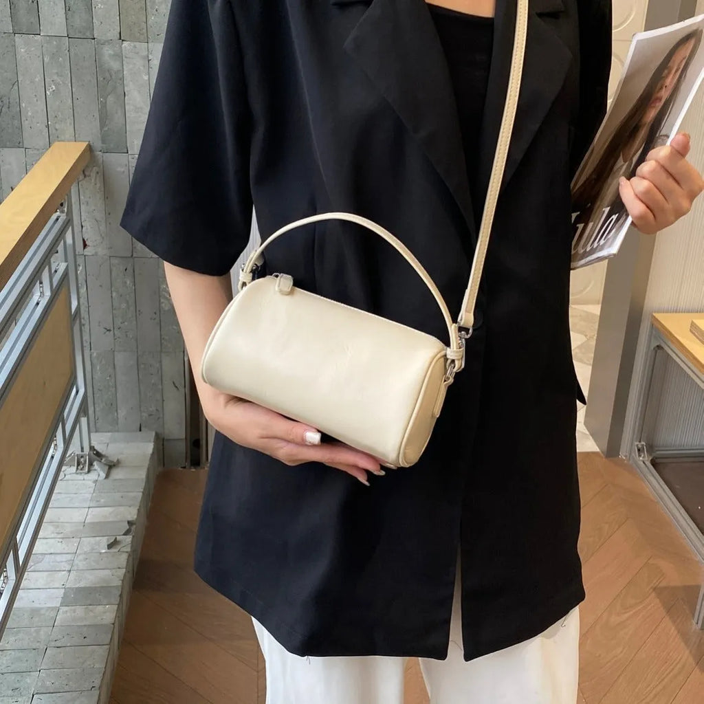 Soft genuine leather cylindrical crossbody phone bag in brown with a single shoulder strap.