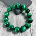 Green Tiger Eye stone beaded bracelet showing polished geometric beads on a wrist.