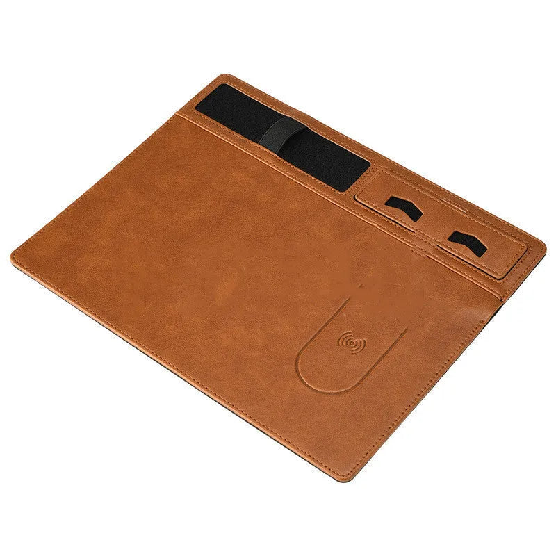 Pink PU leather wireless charging mouse pad with phone holder on a desk, showing USB cable.