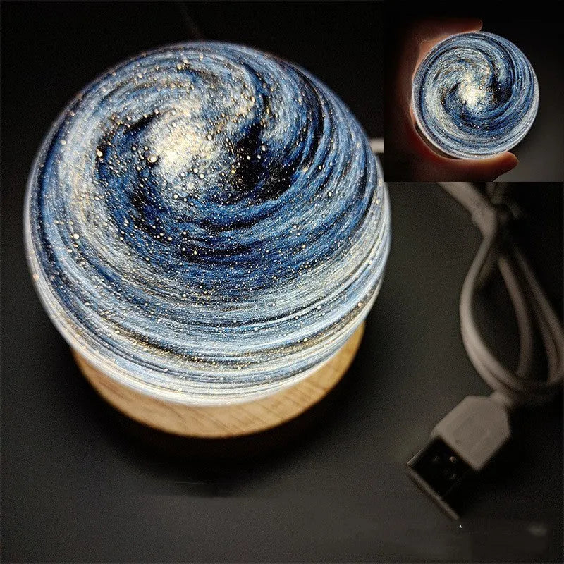 Planet night light with spherical design on base, USB cable connected, showing adjustable three-colour lighting
