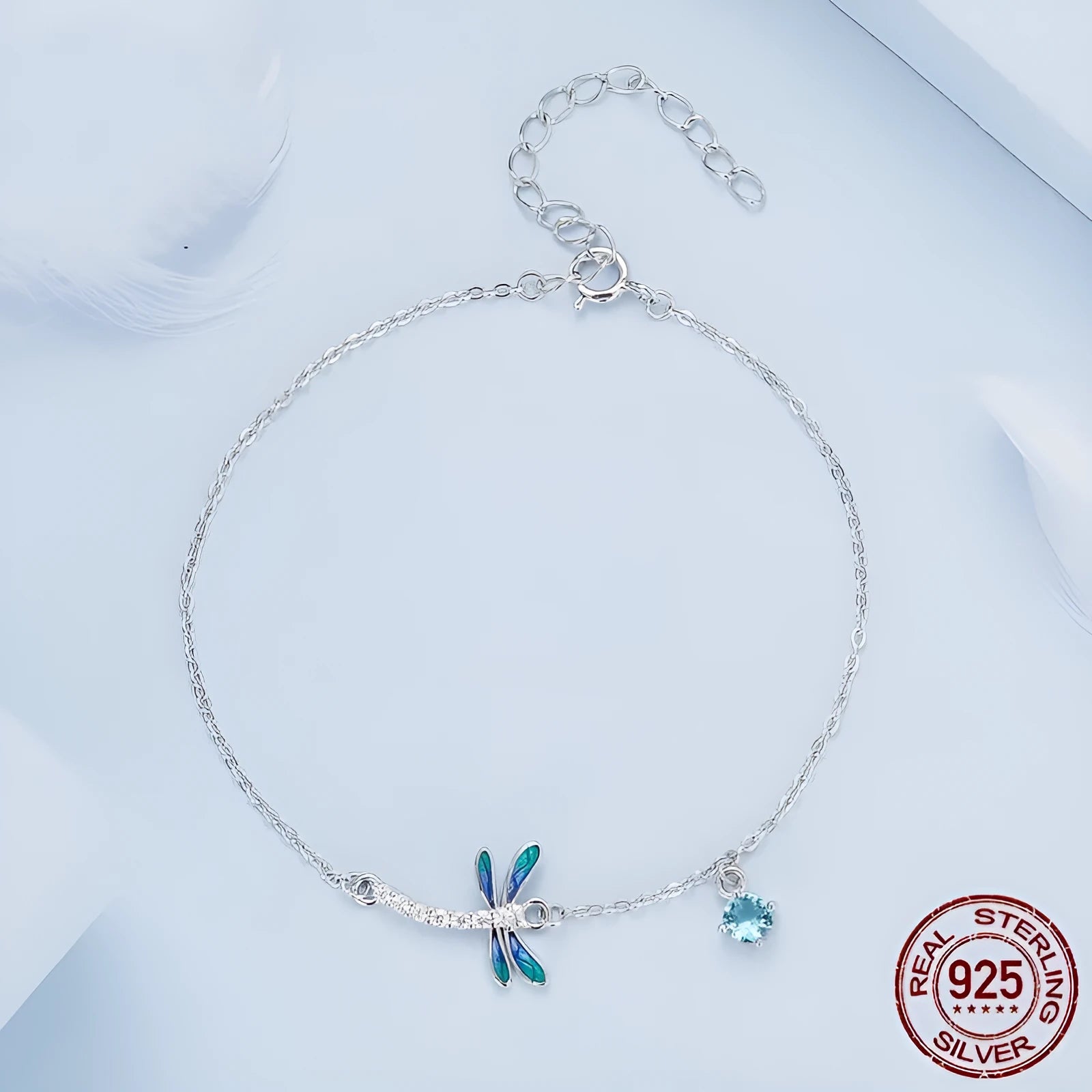Sterling silver white gold plated dragonfly bracelet with dripping cubic zirconia stones on a light background