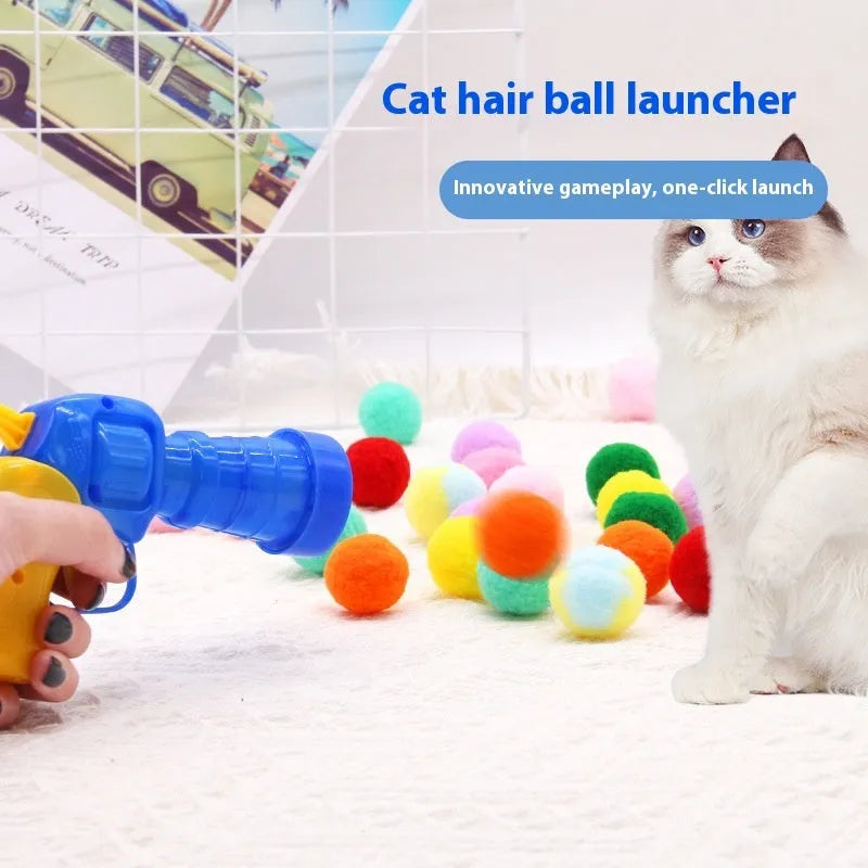 Pet toy launcher gun and soft plush balls for interactive play with cats and dogs.