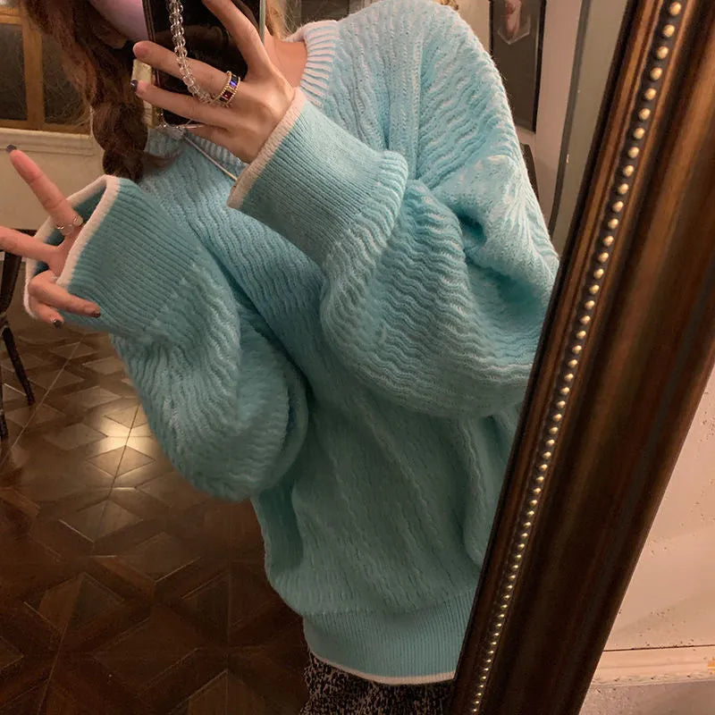 A woman's loose-fit solid colour pullover sweater in a retro style, shown in lake blue.
