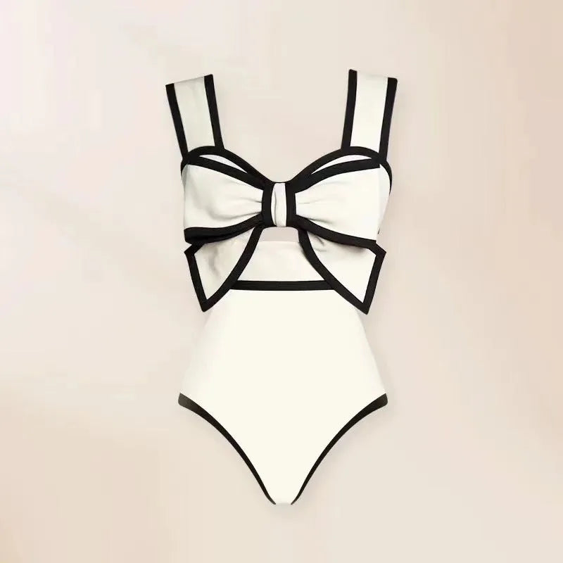 Women's black one-piece swimsuit with white attached skirt beach dress and bow trim