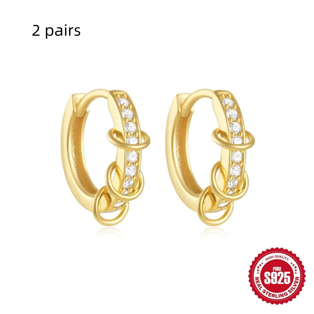 A pair of small, round, geometric stud earrings made of sterling silver with an electroplated finish.