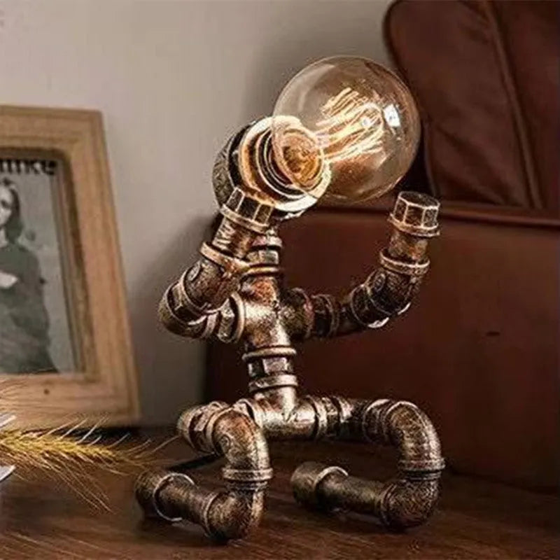 Industrial vintage table lamp shaped like a robot made from iron water pipes in a retro colour.