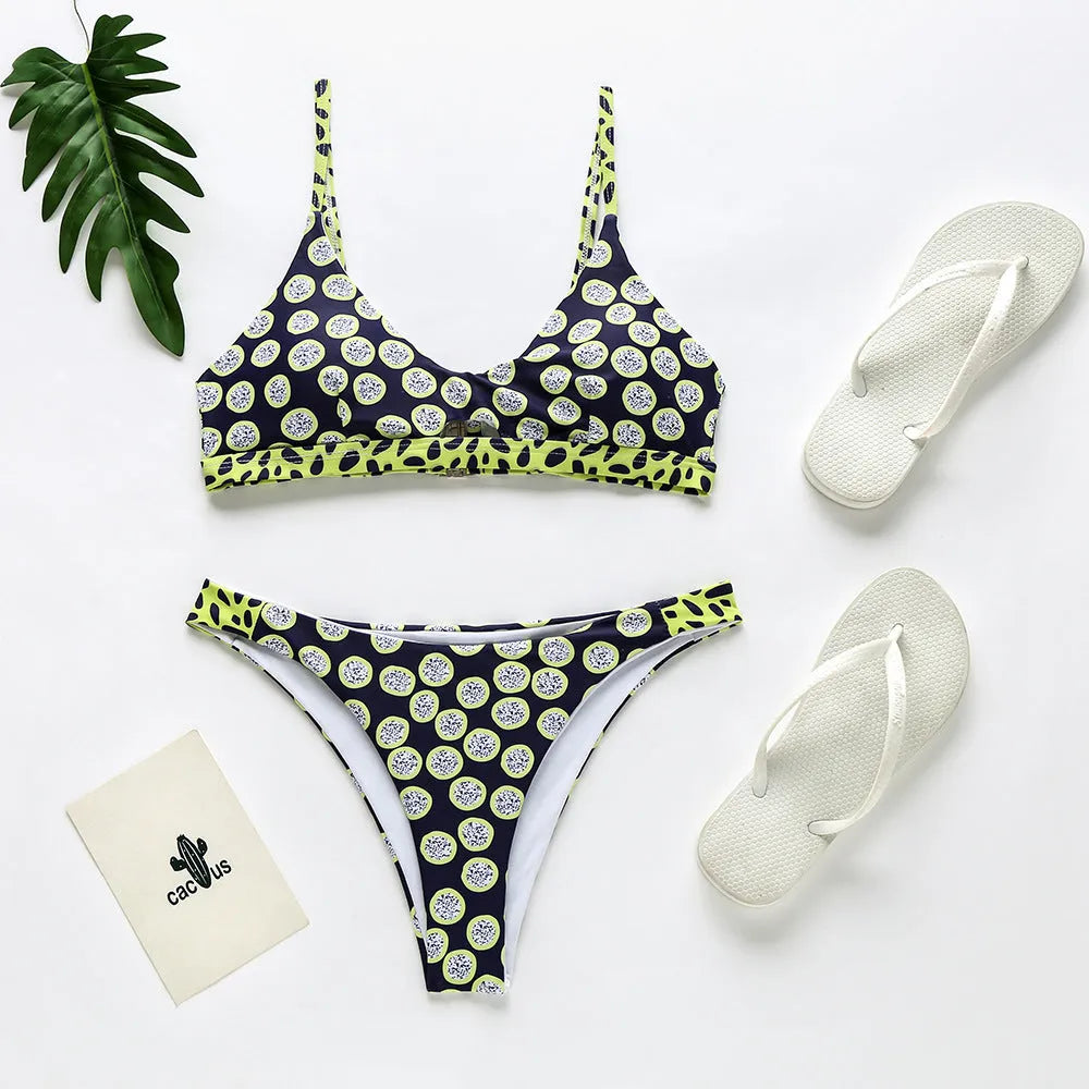 Women's black and white dot polyester bikini set laid flat, showing top and bottom pieces.