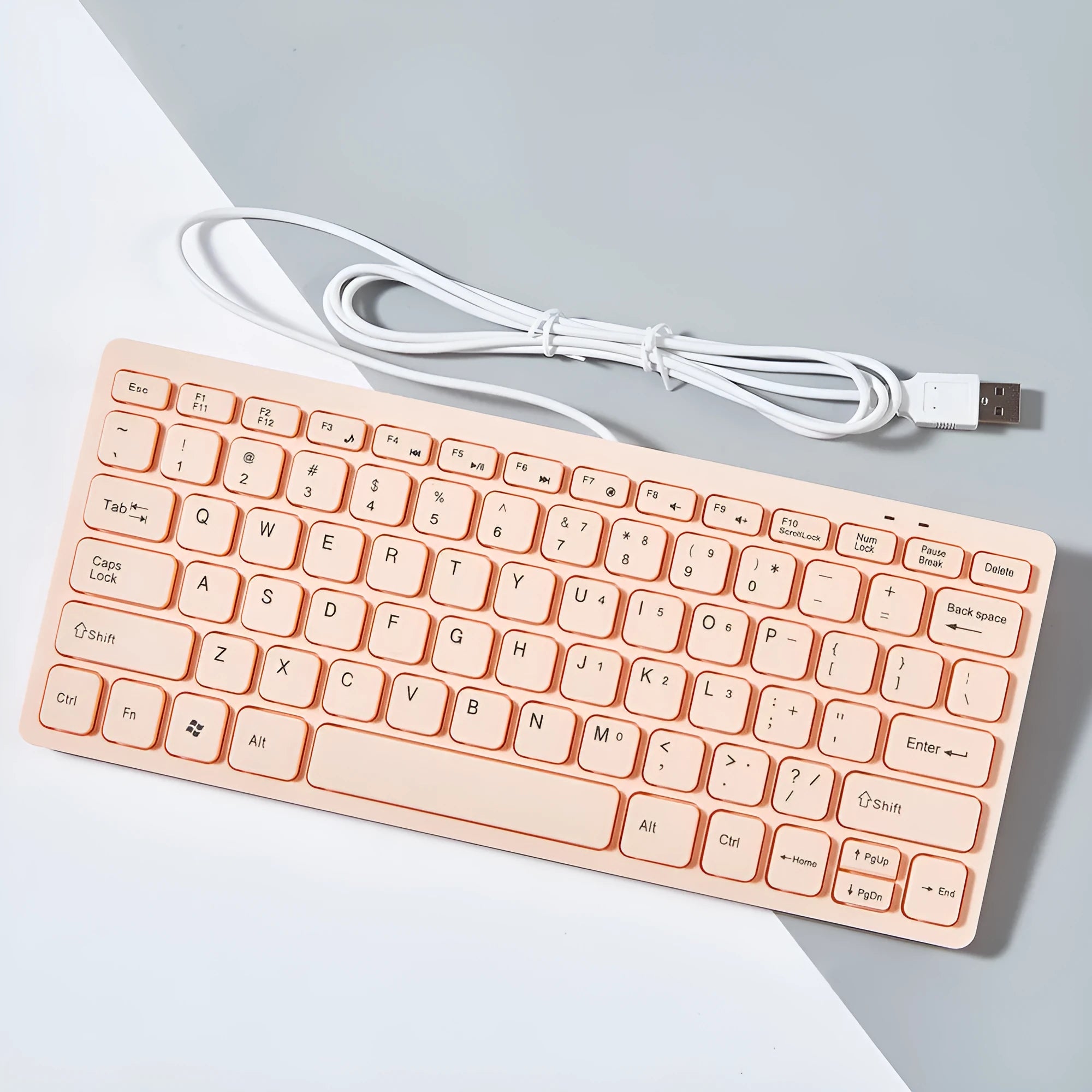 Compact USB wired mini keyboard in black, white, pink, or blue on a desk.