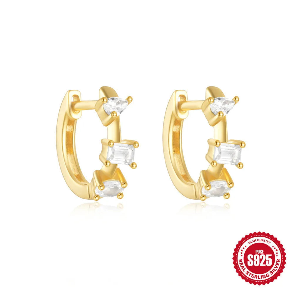A pair of small, round, geometric stud earrings made of sterling silver with an electroplated finish.