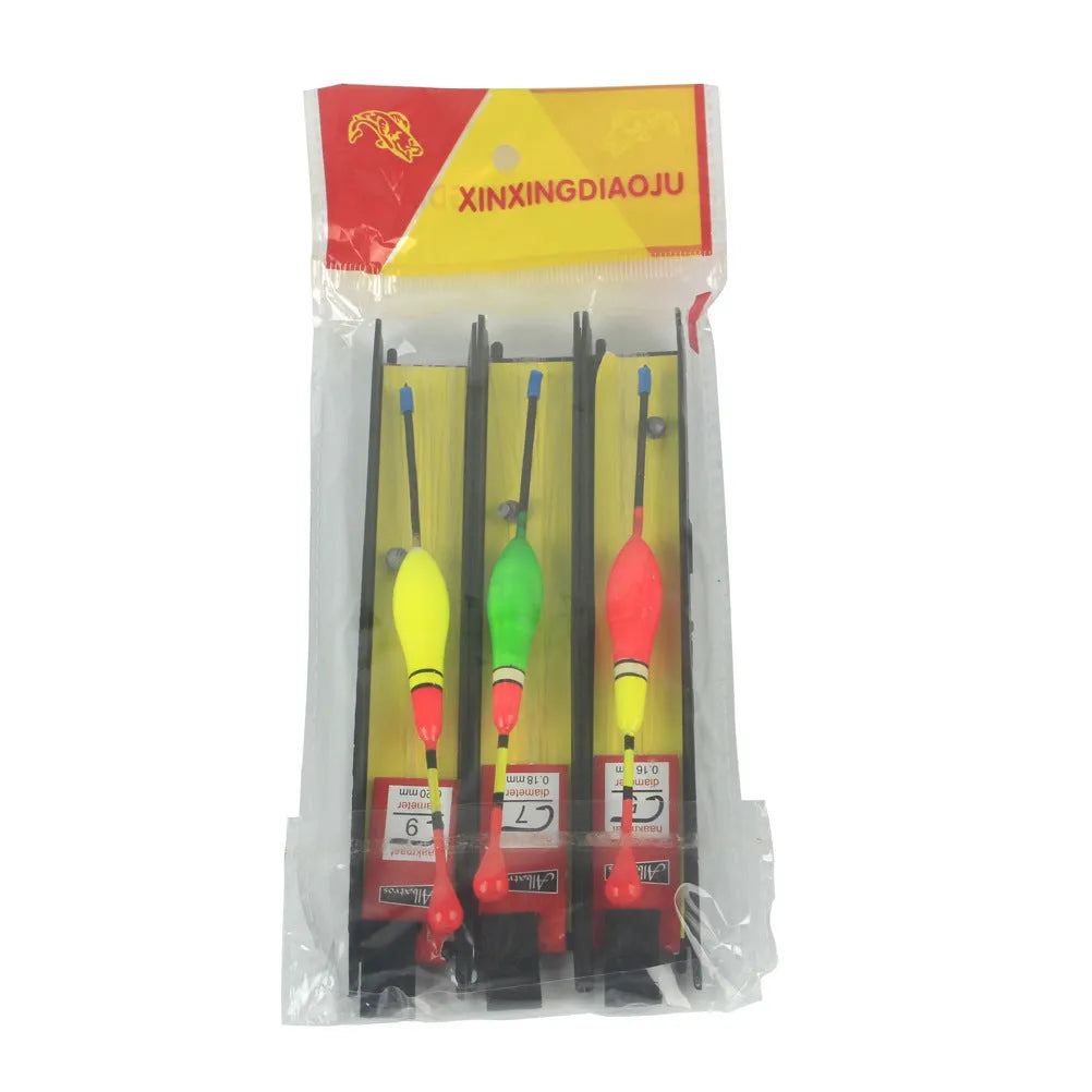 Three plastic vertical fishing floats with wire group and double hook on a dark background