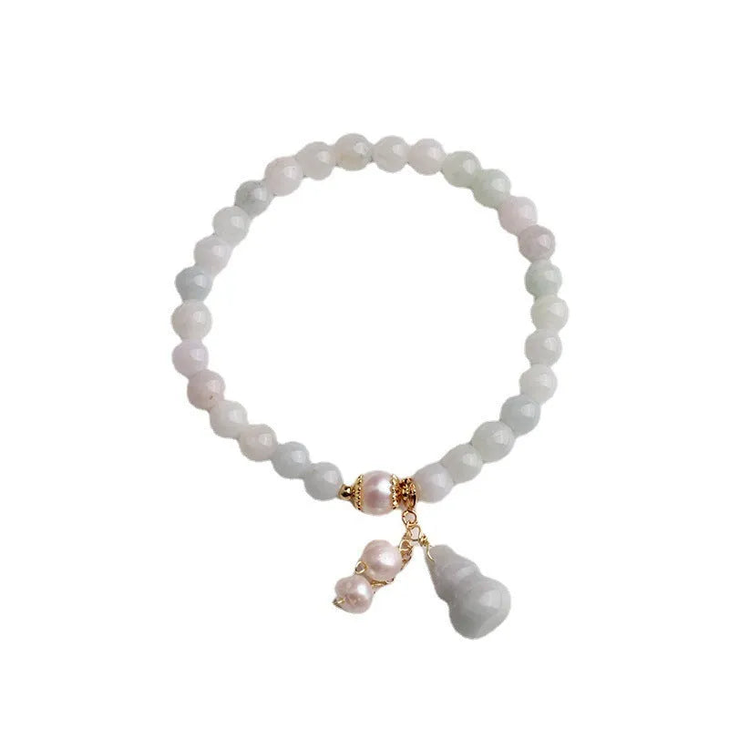 Close-up of a natural emerald jade bracelet with a detailed pearl jade gourd charm pendant.