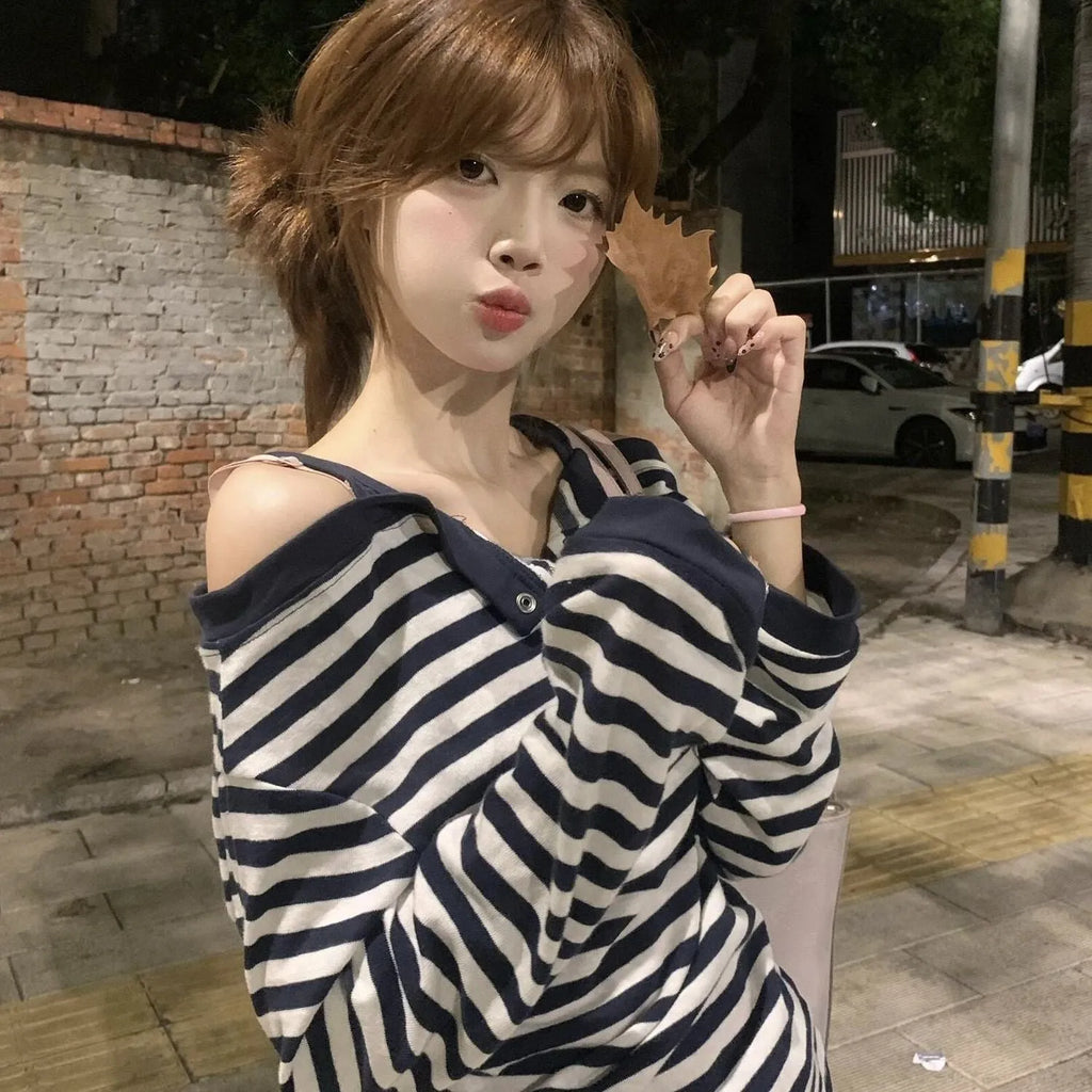 Dark blue oversized women's long-sleeve t-shirt with stripes, button detail, and embroidery on the front.