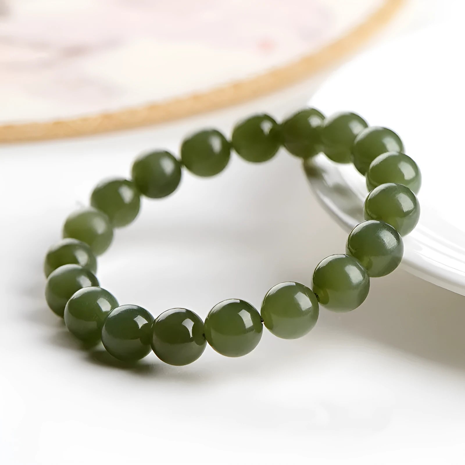 Polished Hetian jade bead bracelet in clear ice-like colours on a white background.