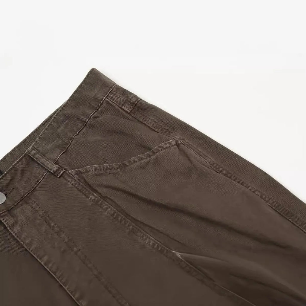 Men's brown loose straight leg high waist cotton trousers laid flat.
