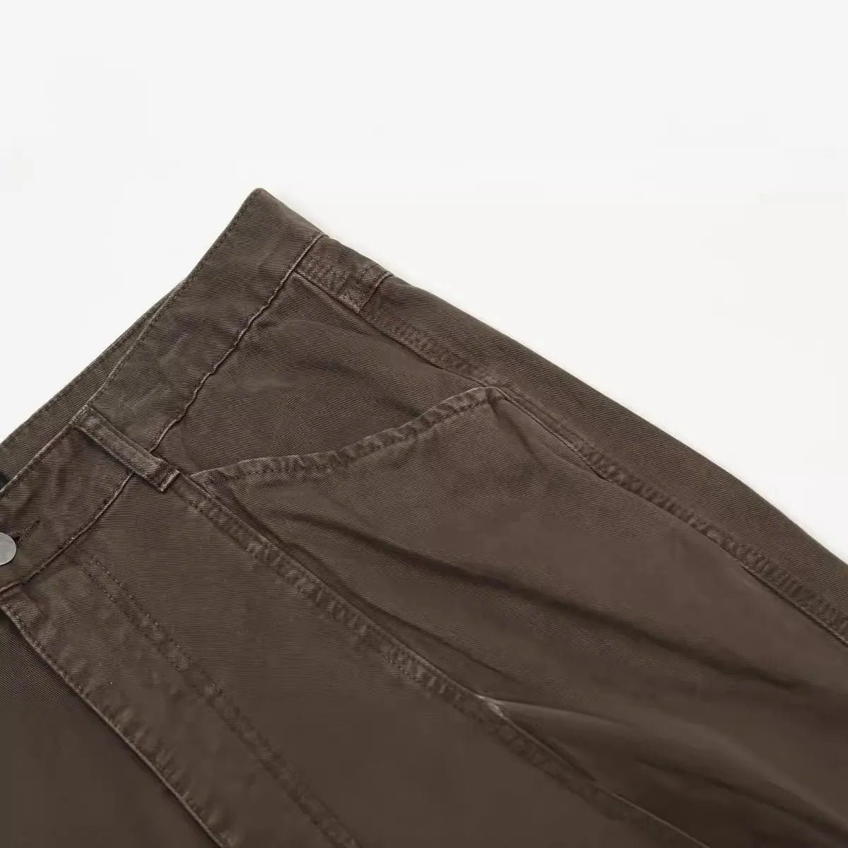 Men's brown loose straight leg high waist cotton trousers laid flat.