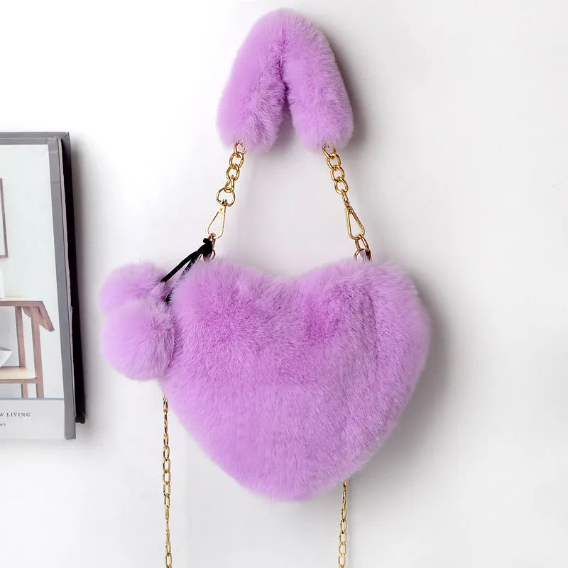 A soft, heart-shaped plush handbag for women in a medium size with a detachable shoulder strap.