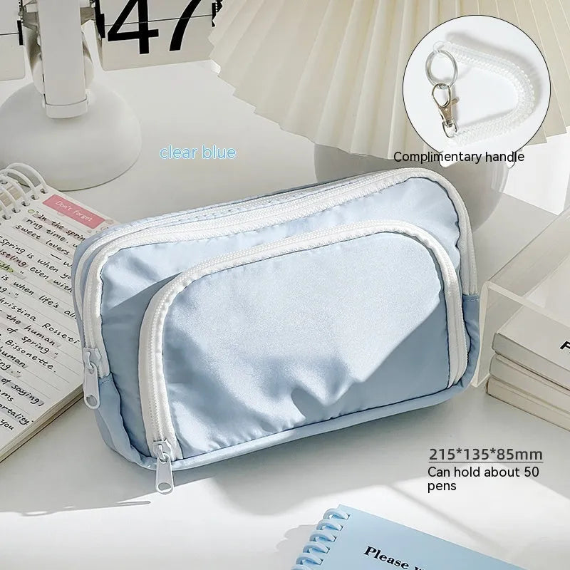 Double-layer pencil case in mint green with gift handle, showing internal divider for stationery organisation