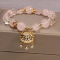 Yellow agate crystal bracelet with gold silk adjustable cord on a wrist, showing khaki coloured beads.