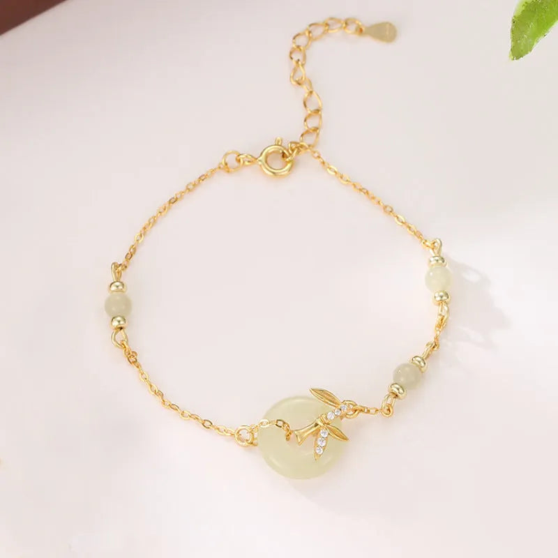 Women's antique style Hetian jade bracelet with a silver peace buckle clasp on a wrist.