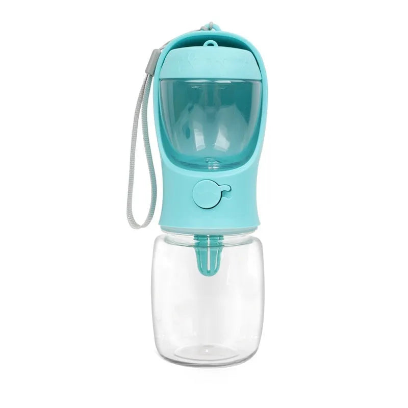 A blue portable plastic dog water bottle with an integrated flip-out drinking bowl on a green background.