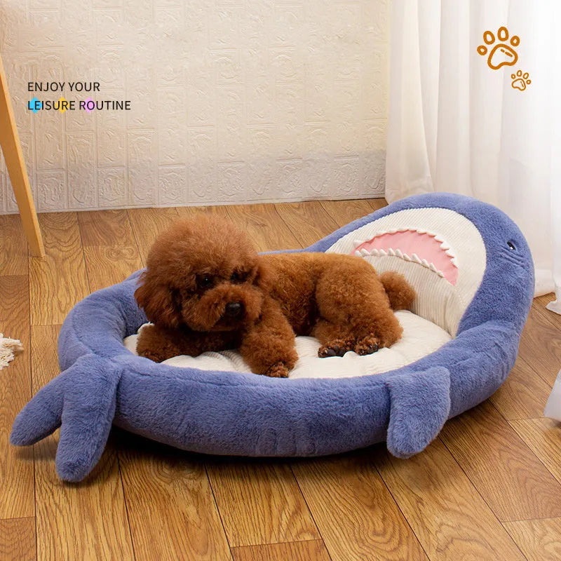 Blue shark pattern pet bed cushion on a floor, showing soft velvet material and non-slip base.
