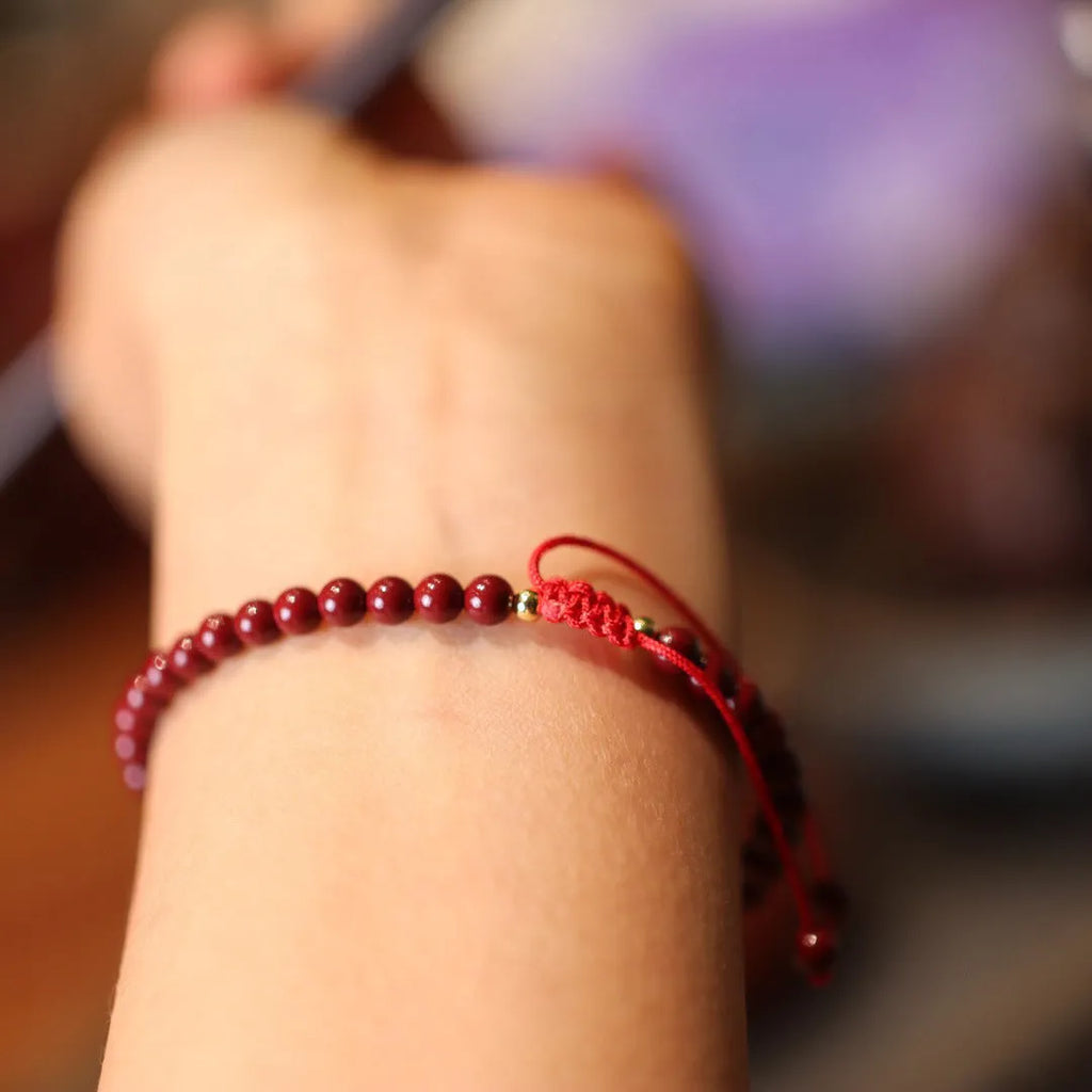Close-up of a purple gold sand cinnabar bracelet with geometric shapes and auspicious patterns.