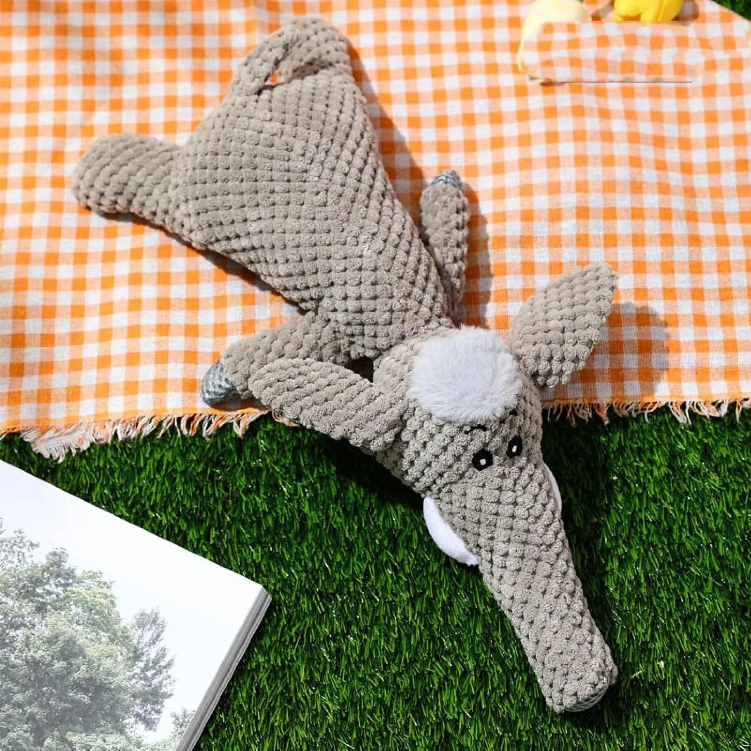 Green plush dog chew toy shaped like an animal with a corn kernel texture and a squeaker inside.