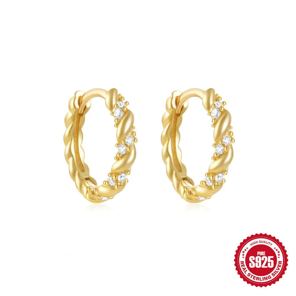A pair of small, round, geometric stud earrings made of sterling silver with an electroplated finish.