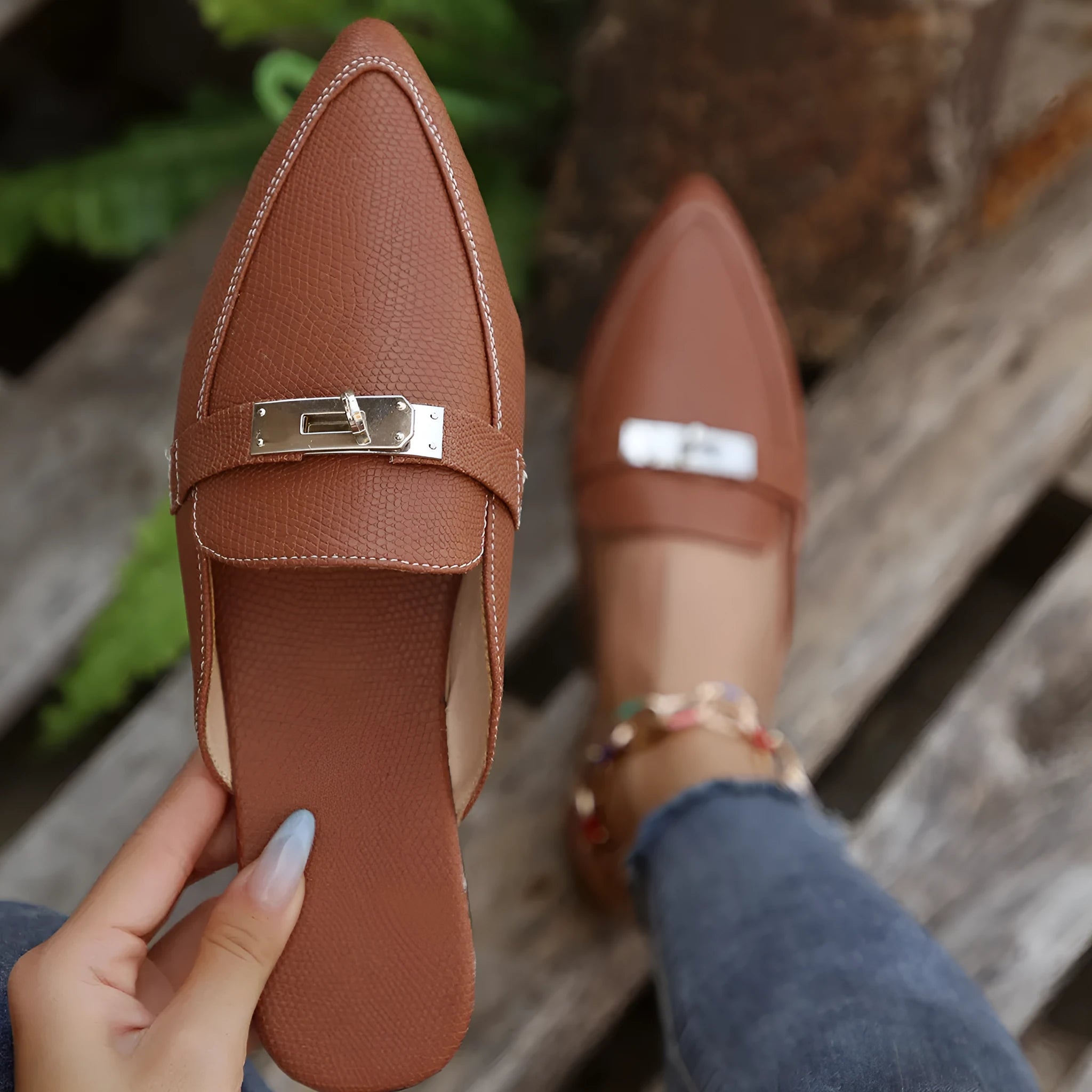 Light brown women's pointed toe low heel slippers with a rubber sole on a plain background.