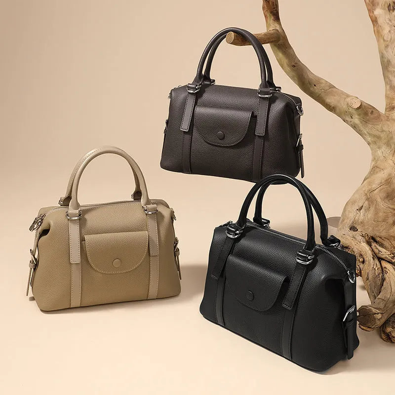 Black genuine leather ladies handbag with single shoulder strap, showing contrast lock and stitching.