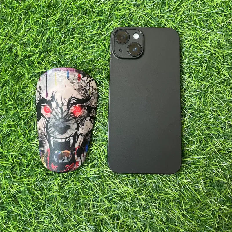 Extra small black and white plastic football shin guards for youth players, size 8cm by 5cm.
