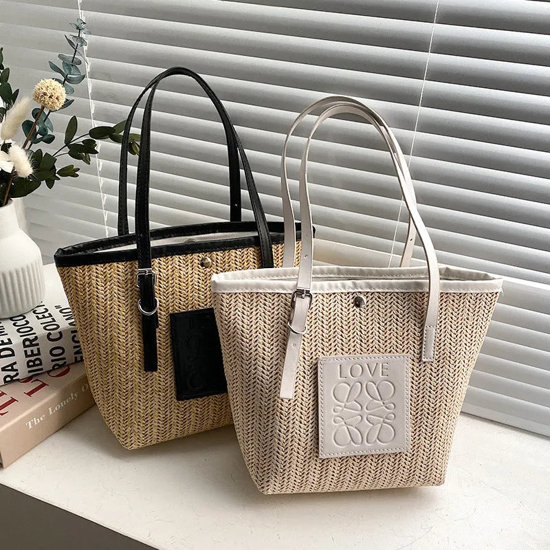 Women's straw woven shoulder bag with PU trim showing tapered shape and sewn thread details