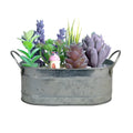 Galvanised iron cylindrical succulent flower pot with a drainage hole on a desk.