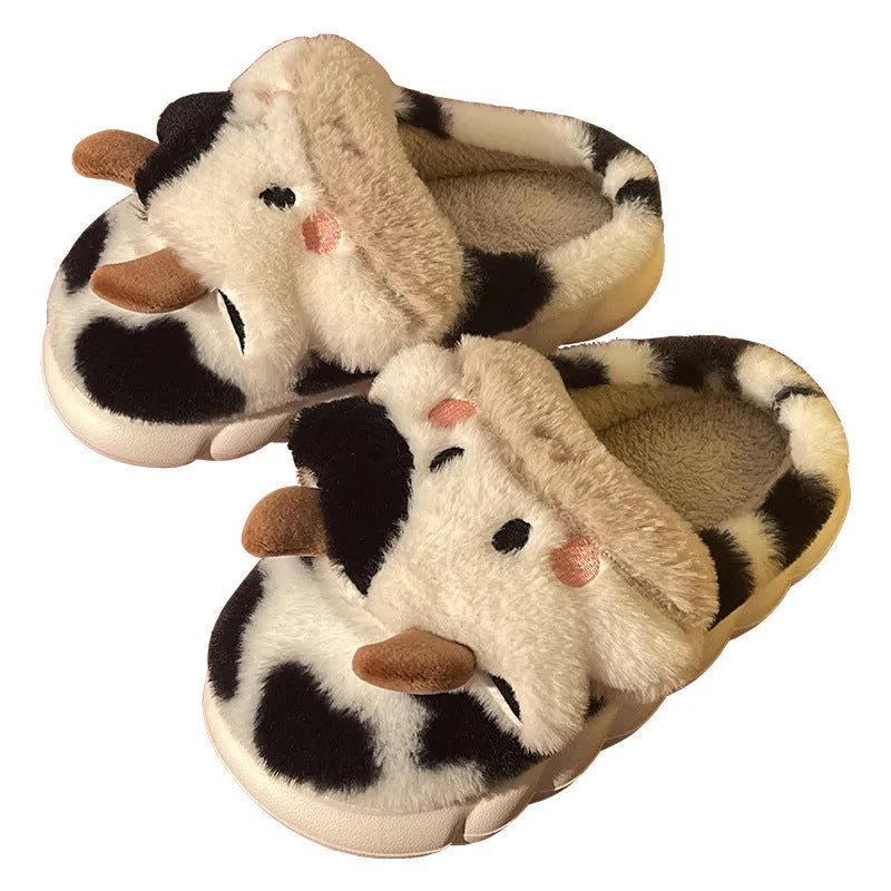 White cartoon cow plush house slippers for women with a non-slip textured sole.