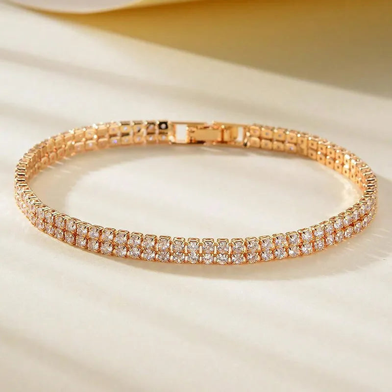 Unisex gold electroplated double-row diamond zirconia tennis chain bracelet on white background