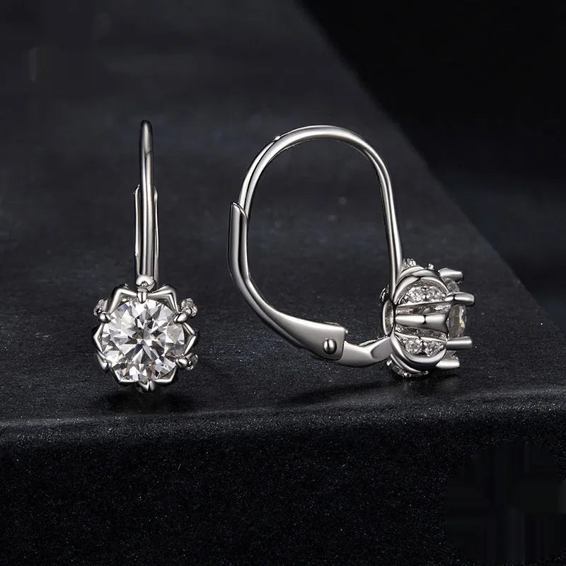 A pair of sterling silver flower bud design ear clips with white gold plating and moissanite stones.