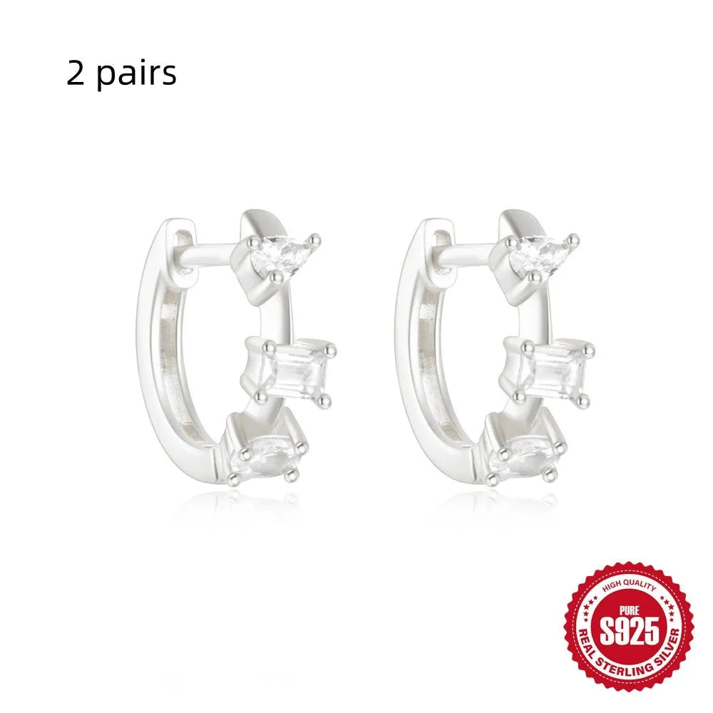 A pair of small, round, geometric stud earrings made of sterling silver with an electroplated finish.