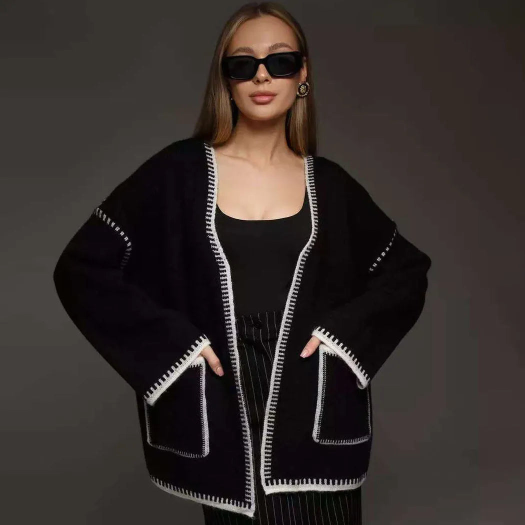 Loose fit camel coloured knitted cardigan sweater with long sleeves laid flat.
