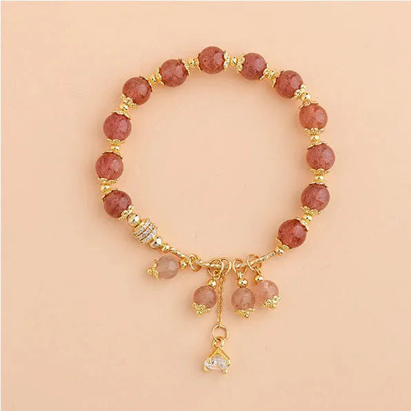 Pink women's bracelet with heart-shaped strawberry quartz crystal beads and freshwater pearl accents on a wrist.
