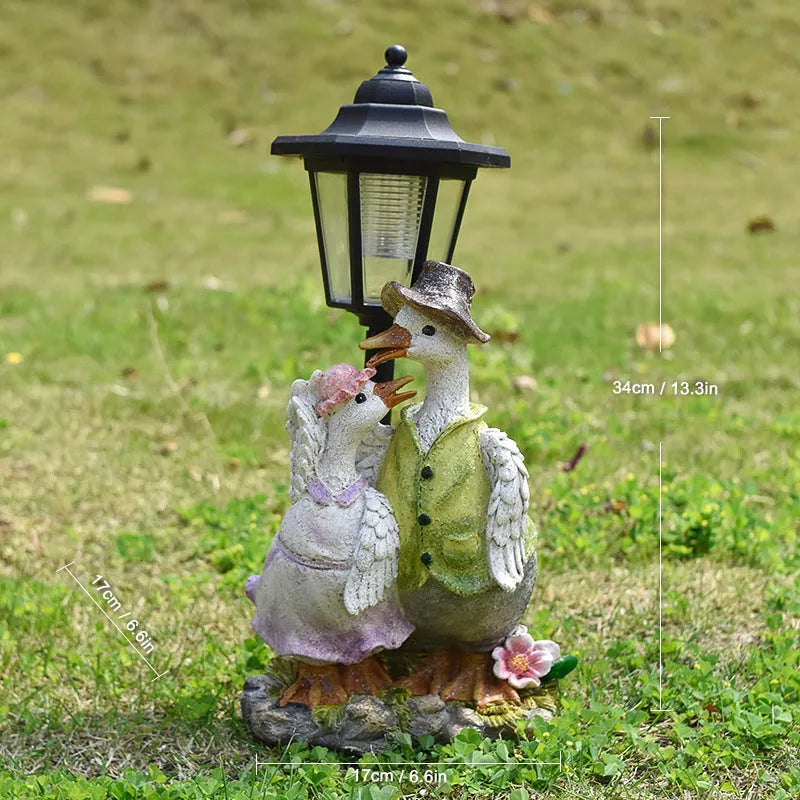Solar hexagonal garden lamp with decorative resin figurine on plastic base for outdoor pathway lighting