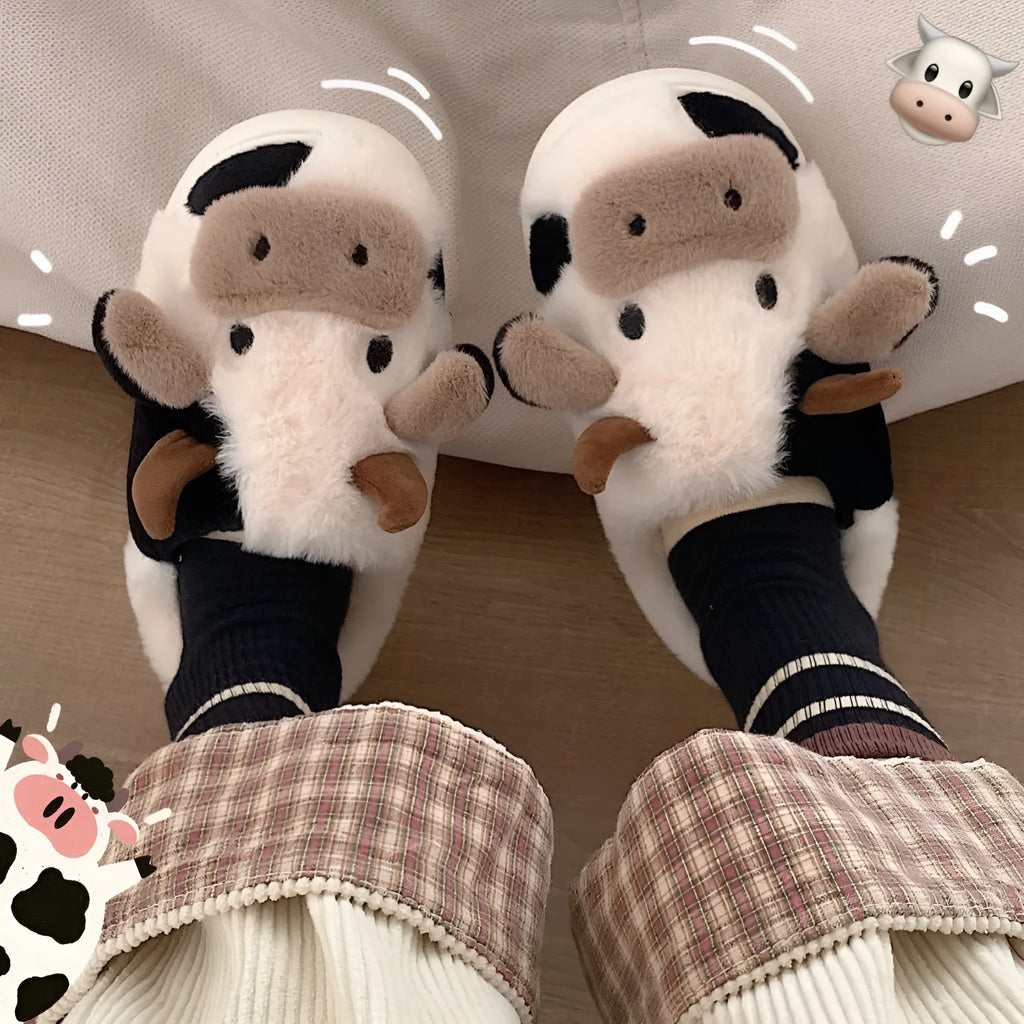 White cartoon cow plush house slippers for women with a non-slip textured sole.